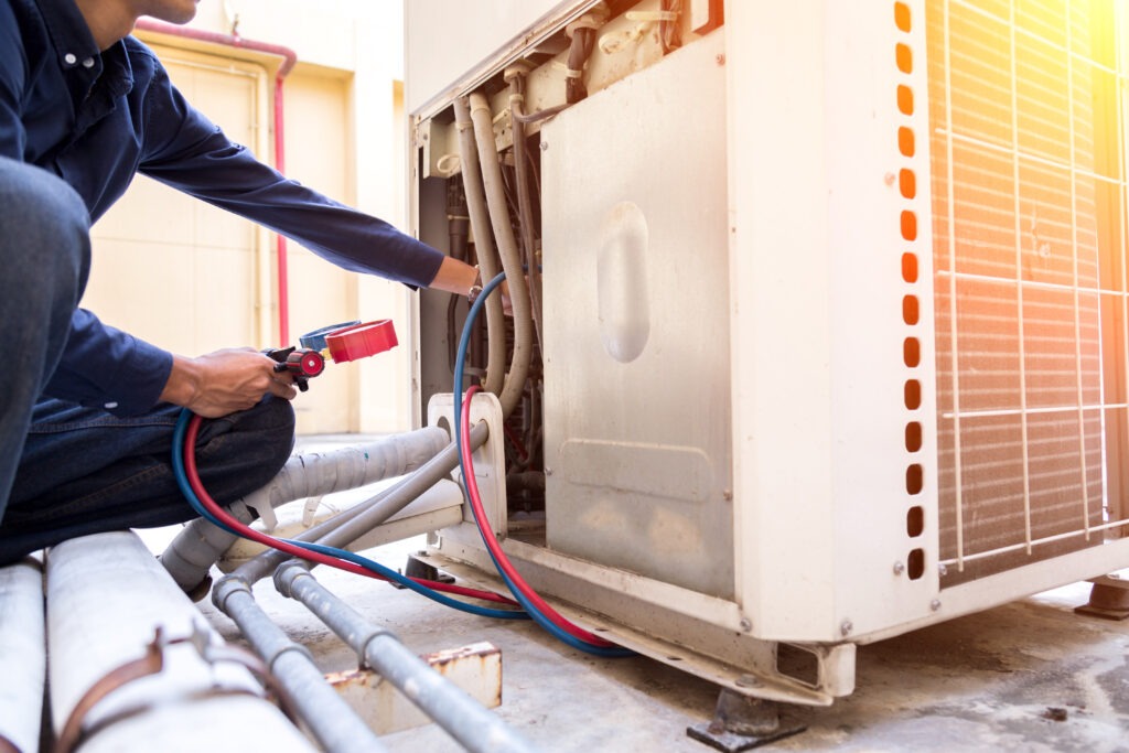 Air conditioning engineer carrying out maintenance on an outdoor air conditioning unit